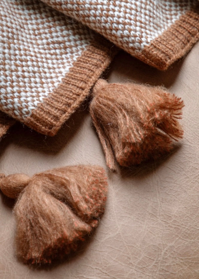 Soft chunky knit with tassel detailing. Rust.
